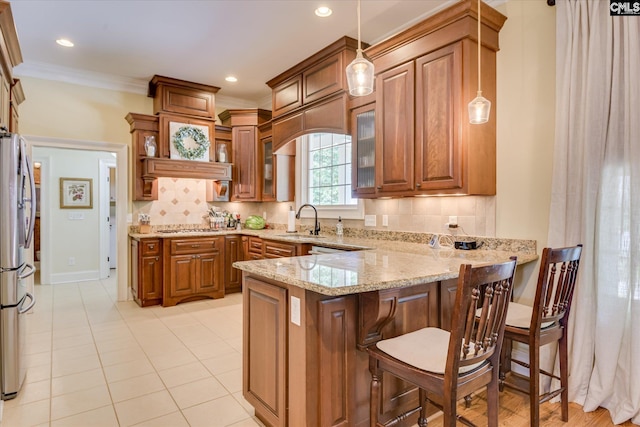3450 Summerland Hwy, Leesville, SC 29070 - kitchen with stainless steel appliances, a peninsula, brown cabinetry, light stone countertops, and glass insert cabinets