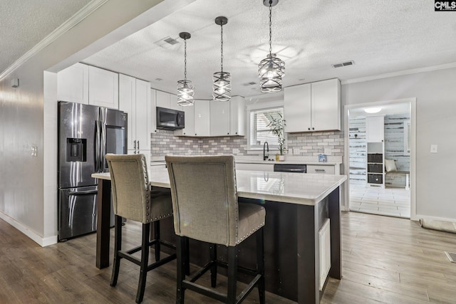 2032 Pinewood St, Cayce, SC 29033 - kitchen with stainless steel refrigerator with ice dispenser, a textured ceiling, light countertops, decorative backsplash, and white cabinetry