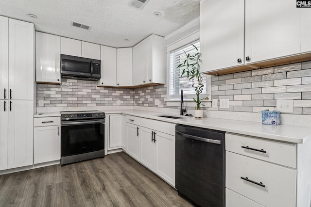 2032 Pinewood St, Cayce, SC 29033 - kitchen with black dishwasher, stainless steel range with electric cooktop, light countertops, white cabinets, and a textured ceiling