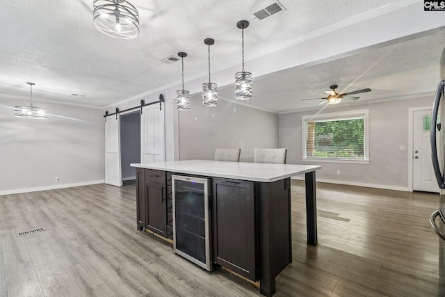 2032 Pinewood St, Cayce, SC 29033 - kitchen with beverage cooler, open floor plan, a textured ceiling, a barn door, and ornamental molding