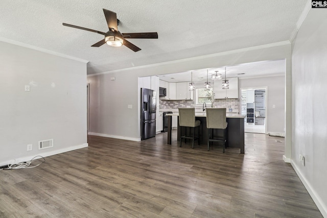 2032 Pinewood St, Cayce, SC 29033 - kitchen featuring black appliances, a ceiling fan, ornamental molding, white cabinetry, and a center island with sink
