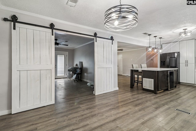 2032 Pinewood St, Cayce, SC 29033 - kitchen with a barn door, a textured ceiling, wine cooler, ornamental molding, and stainless steel fridge