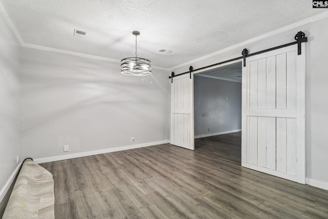 2032 Pinewood St, Cayce, SC 29033 - empty room with a barn door, wood finished floors, a textured ceiling, and ornamental molding
