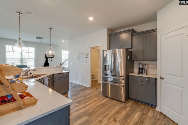 1056 Turtle Stone Rd, Blythewood, SC 29016 - kitchen with stainless steel refrigerator with ice dispenser, gray cabinetry, dark wood-type flooring, backsplash, and hanging light fixtures