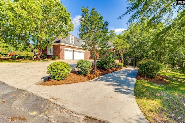 201 Arcadia Lakes Dr, Columbia, SC 29206 - view of property hidden behind natural elements with driveway, brick siding, and an attached garage