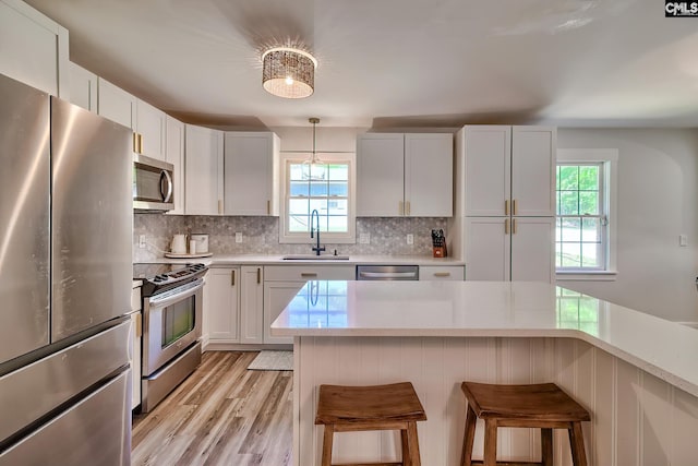 5404 Fairview Rd, Batesburg, SC 29006 - kitchen featuring stainless steel appliances, light countertops, backsplash, a breakfast bar, and light wood-style floors