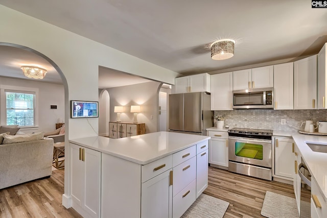 5404 Fairview Rd, Batesburg, SC 29006 - kitchen featuring appliances with stainless steel finishes, arched walkways, light wood-style flooring, open floor plan, and light countertops