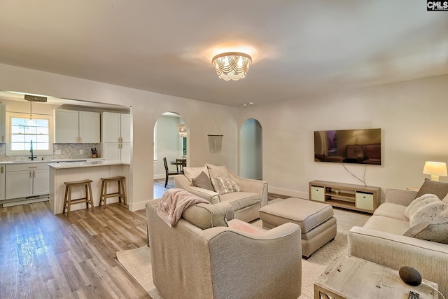 5404 Fairview Rd, Batesburg, SC 29006 - living room featuring arched walkways, light wood-style floors, and a chandelier