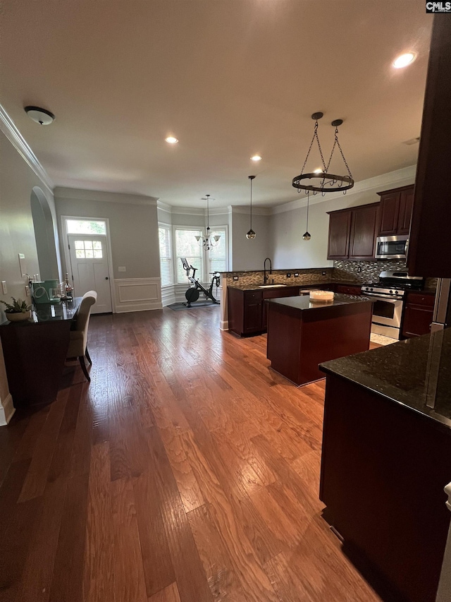 127 Brooklet Dr, Lexington, SC 29072 - kitchen featuring stainless steel appliances, a center island, crown molding, dark brown cabinets, and backsplash