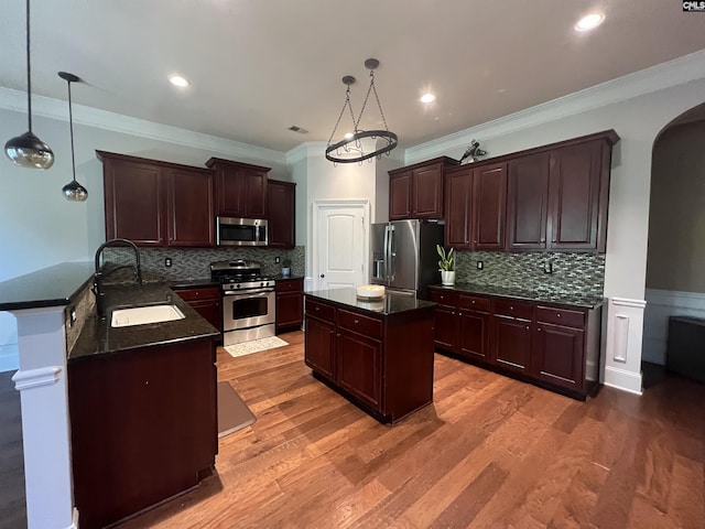 127 Brooklet Dr, Lexington, SC 29072 - kitchen with stainless steel appliances, crown molding, arched walkways, a center island, and light wood finished floors