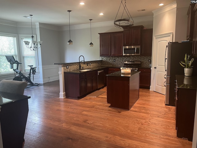 127 Brooklet Dr, Lexington, SC 29072 - kitchen featuring appliances with stainless steel finishes, a peninsula, a kitchen island, light wood finished floors, and dark brown cabinetry