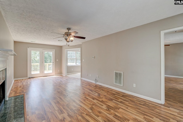 211 Glendevon Way, Columbia, SC 29229 - unfurnished living room with a ceiling fan, a tile fireplace, wood finished floors, and a textured ceiling