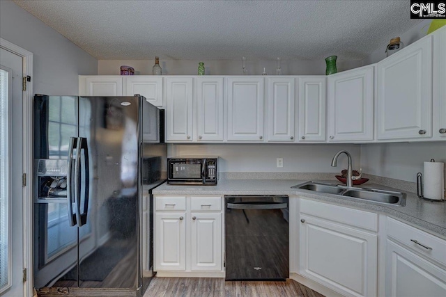 27 Lacebark Ln, Elgin, SC 29045 - kitchen featuring black appliances, white cabinetry, a textured ceiling, light wood-style flooring, and light countertops