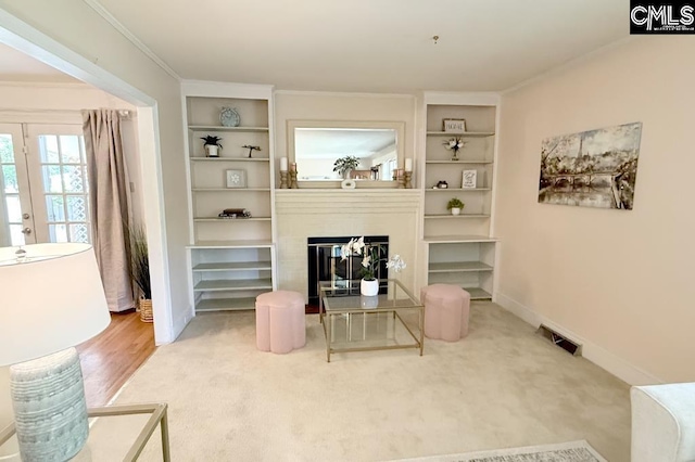 224 17th St, West Columbia, SC 29169 - carpeted living room with built in features, a glass covered fireplace, and crown molding