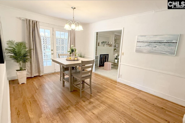 224 17th St, West Columbia, SC 29169 - dining room featuring light wood-style floors, a chandelier, crown molding, and a glass covered fireplace