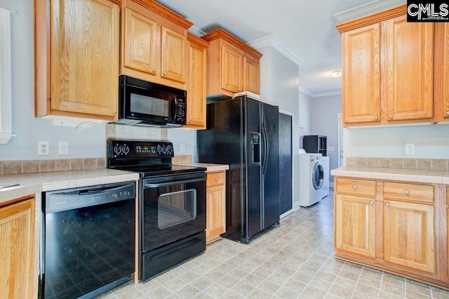 kitchen with crown molding, washer / dryer, light tile flooring, and black appliances