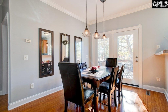 dining area featuring crown molding and dark wood-type flooring