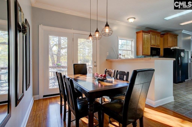 tiled dining space with an inviting chandelier, ornamental molding, and french doors