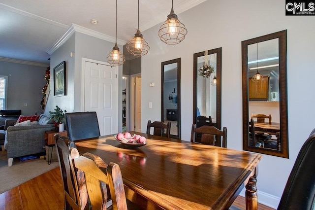 dining area featuring ornamental molding and dark colored carpet