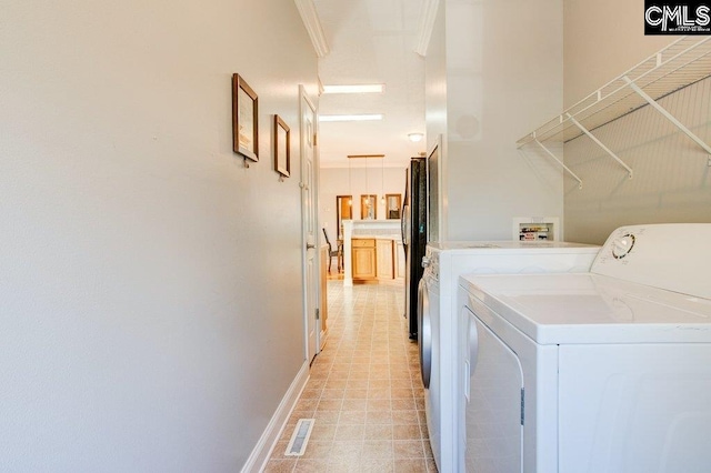 washroom featuring crown molding, washer and dryer, washer hookup, and light tile floors