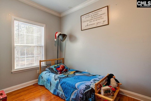 bedroom with multiple windows, light hardwood / wood-style floors, and ornamental molding