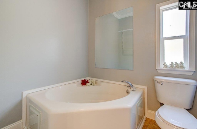 bathroom featuring tile flooring and toilet