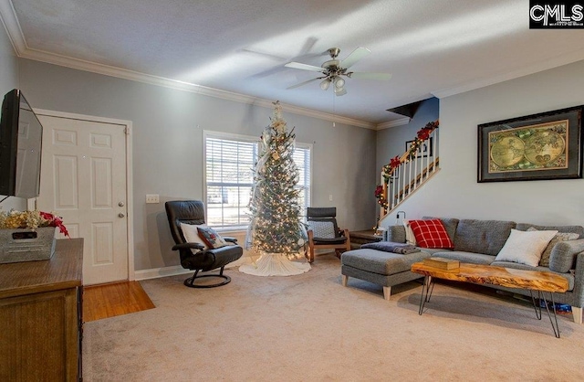 carpeted living room featuring crown molding and ceiling fan