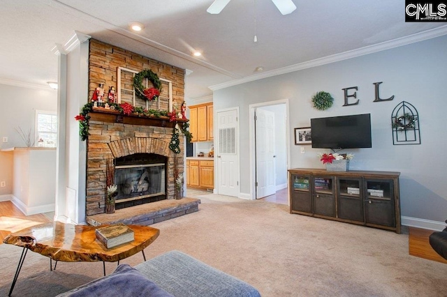 carpeted living room featuring ceiling fan, crown molding, and a fireplace