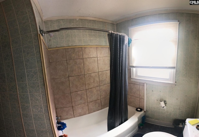 bathroom with shower / bath combo with shower curtain, toilet, and tile walls