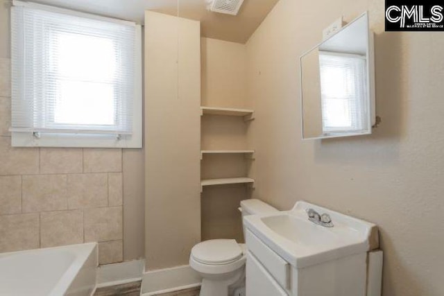 bathroom featuring toilet, a healthy amount of sunlight, and vanity