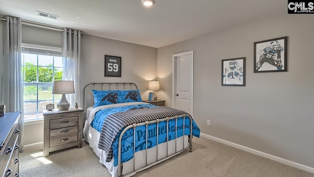 bedroom featuring light carpet and multiple windows