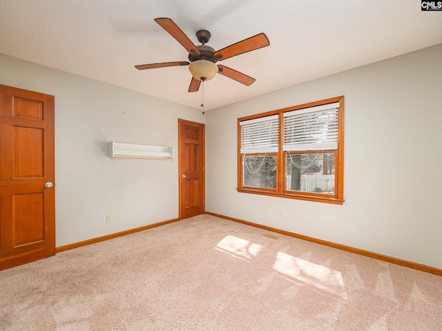 carpeted spare room with ceiling fan and a wall mounted AC