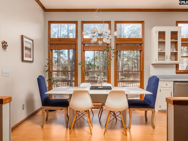 dining room featuring crown molding, light hardwood / wood-style flooring, and a healthy amount of sunlight