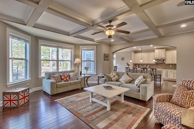 living room featuring ceiling fan, beam ceiling, coffered ceiling, and dark wood-type flooring