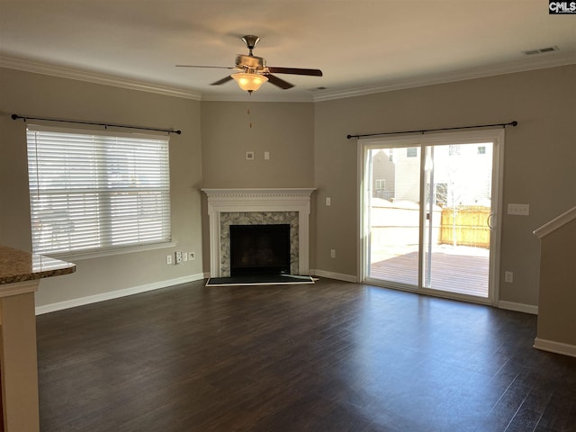 unfurnished living room featuring ceiling fan, crown molding, dark wood-type flooring, and a premium fireplace