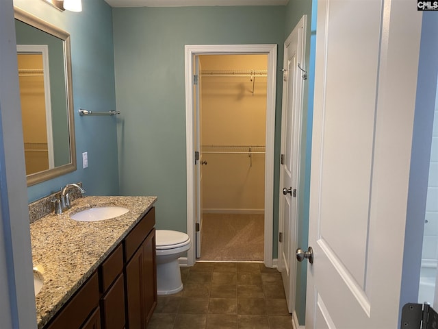 bathroom with toilet, dual bowl vanity, and tile floors