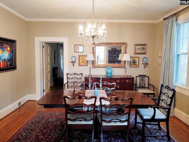 dining room featuring crown molding, dark hardwood / wood-style floors, and an inviting chandelier