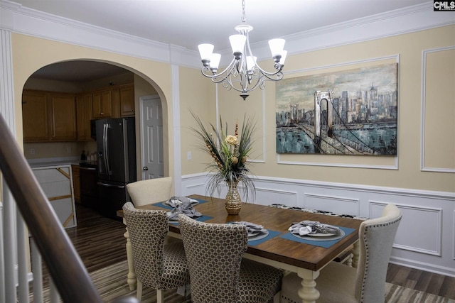 dining space featuring a chandelier, dark hardwood / wood-style floors, and crown molding