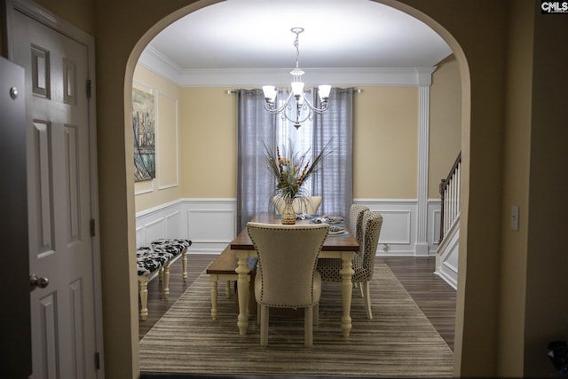 dining area with ornamental molding, dark hardwood / wood-style floors, and an inviting chandelier