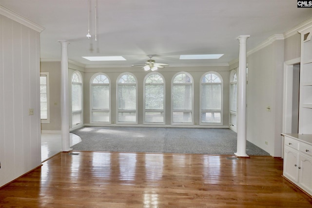 interior space with ceiling fan, ornamental molding, ornate columns, and a skylight