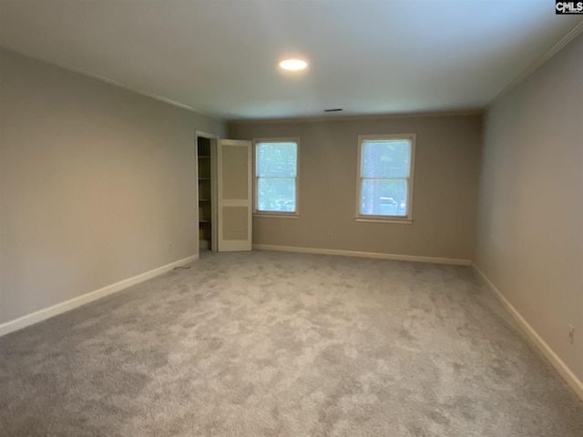 unfurnished room with light colored carpet and ornamental molding