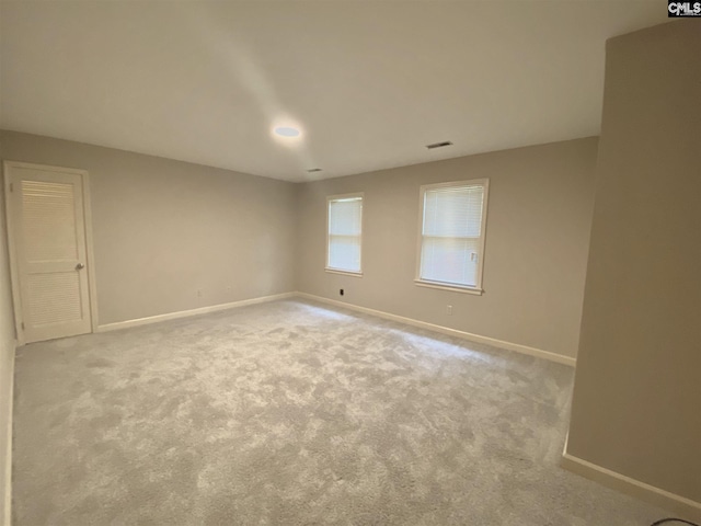 unfurnished room featuring light carpet