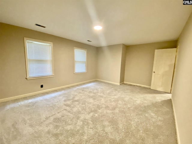 spare room featuring light colored carpet