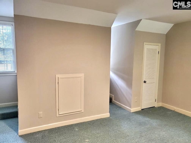 interior space with vaulted ceiling and dark carpet