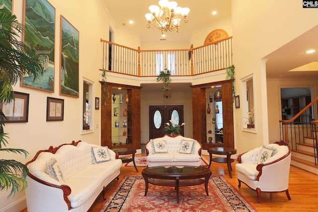 living room featuring a chandelier, hardwood / wood-style floors, and a high ceiling