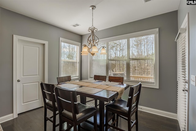 dining area with an inviting chandelier and dark hardwood / wood-style floors