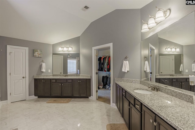 bathroom with double sink vanity, tile flooring, and vaulted ceiling