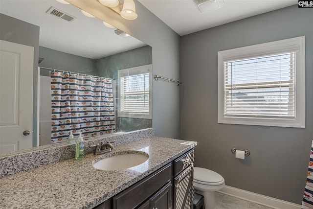 bathroom featuring plenty of natural light, tile floors, oversized vanity, and toilet