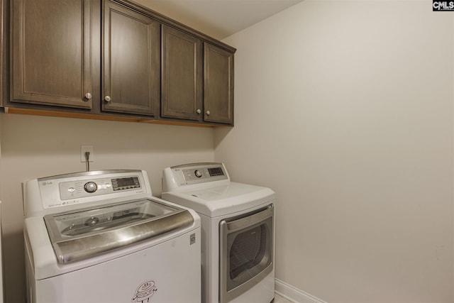 washroom featuring washing machine and dryer and cabinets