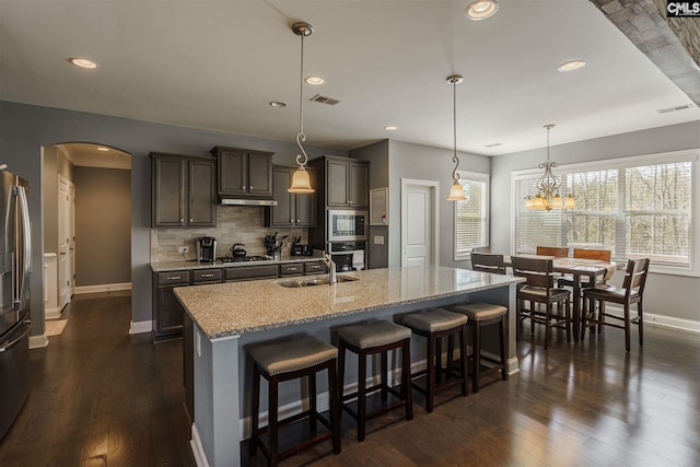 kitchen featuring hanging light fixtures, light stone counters, and dark hardwood / wood-style floors